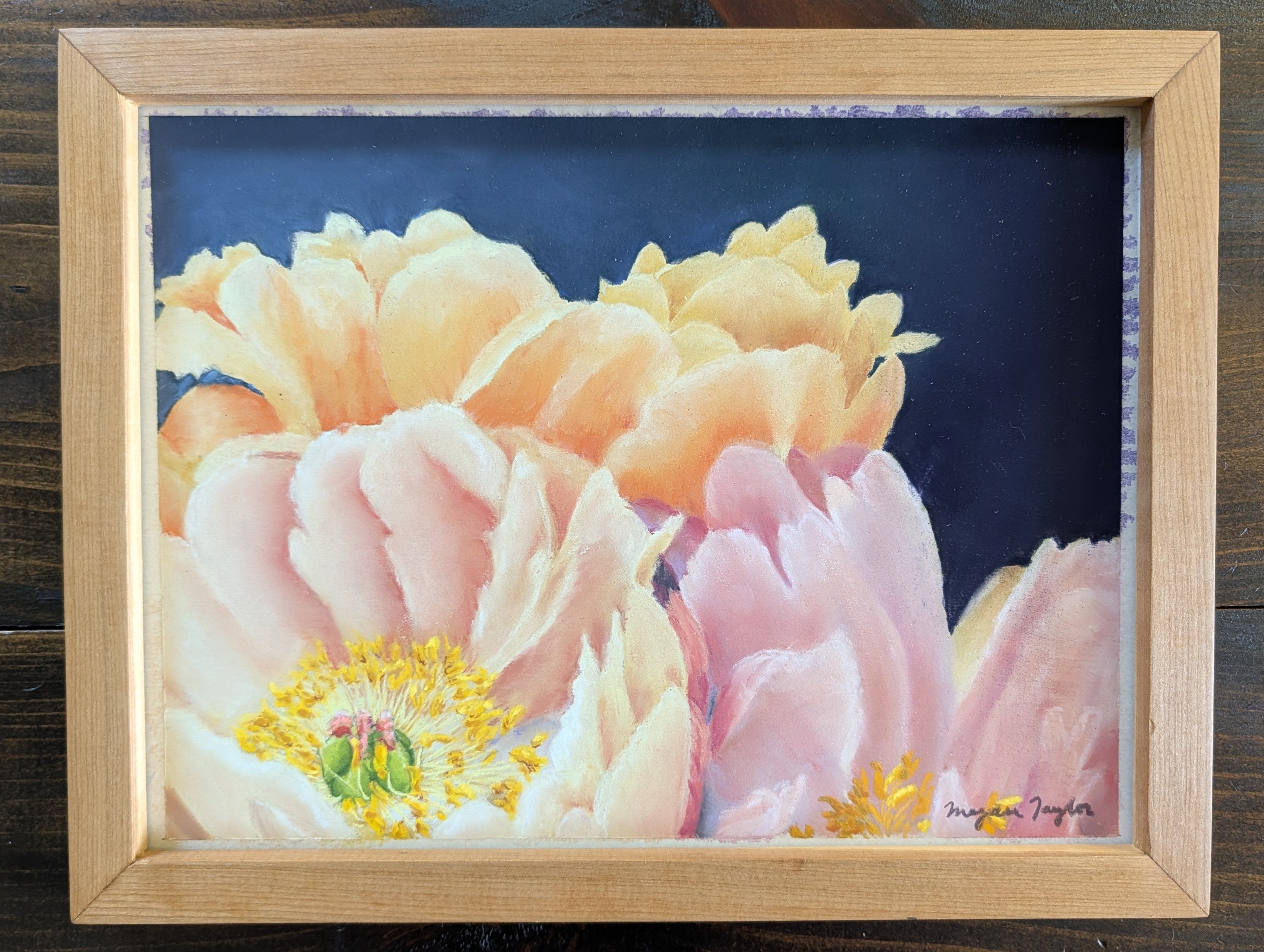 Framed artwork of pink and yellow flowers on a dark background